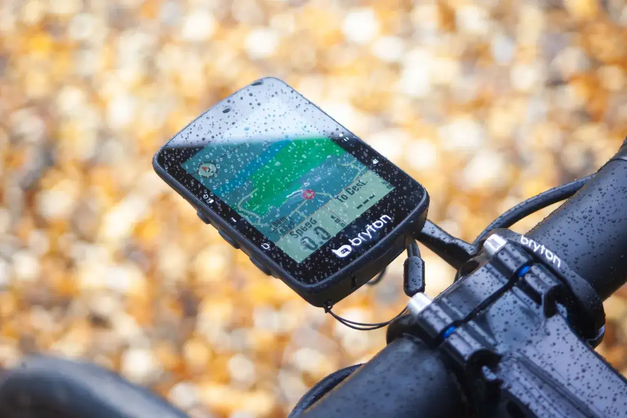 Nawigacja rowerowa Bryton Rider 420, z mapą i danymi o prędkości, pokryta kroplami deszczu. Idealna na wyprawy, nawet w trudnych warunkach, jak na przykład z **hammerhead karoo 3**.