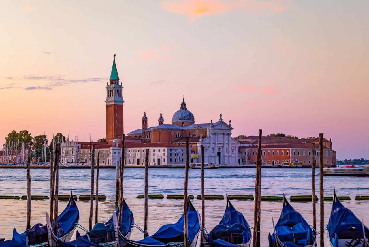Gondoles bleues attendant au coucher du soleil devant l'&icirc;le de San Giorgio Maggiore &agrave; Venise.