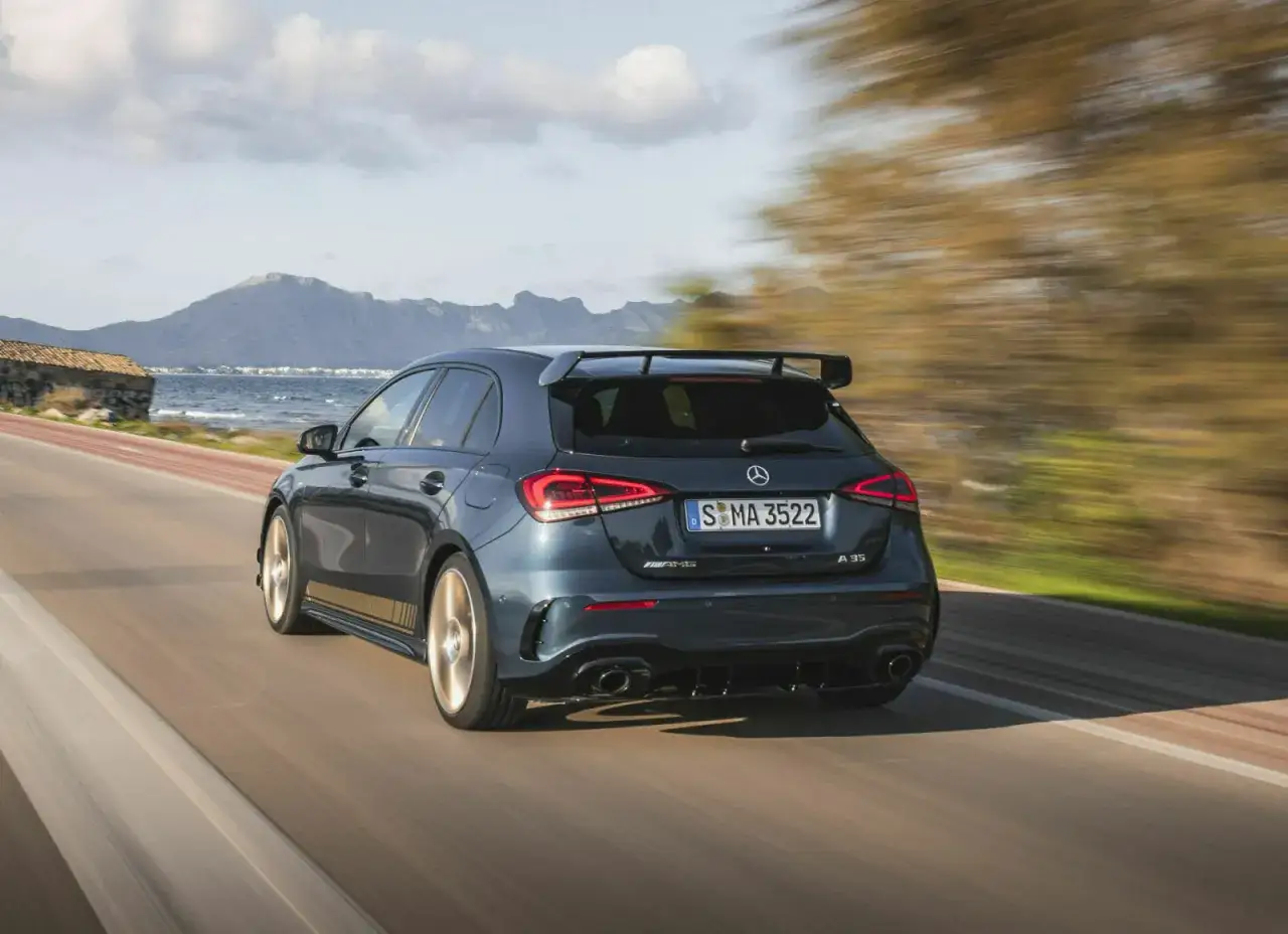Dunkelgrauer Mercedes-AMG A 35 rast auf einer Küstenstraße. Technische Daten sind hier nicht sichtbar, aber die Sportlichkeit ist es.