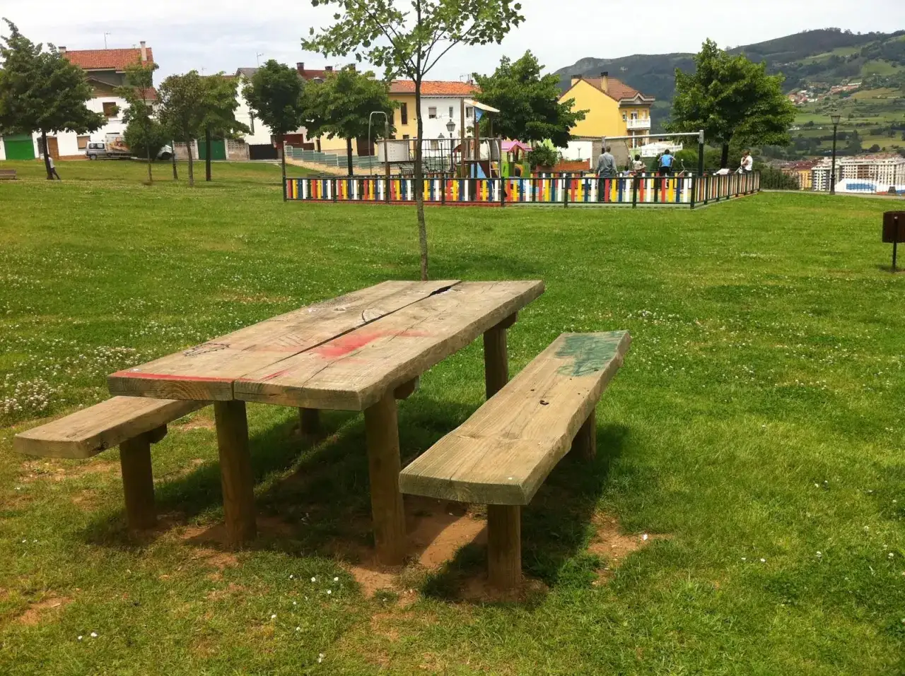 Un parque en Oviedo con una mesa de picnic y un área de juegos para niños. Ideal para disfrutar en familia.