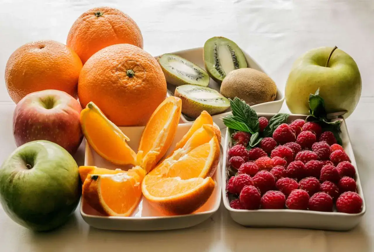 Oranges, pommes, kiwis et framboises, un assortiment de fruits frais. Les framboises sont le fruit avec le plus de fibre.