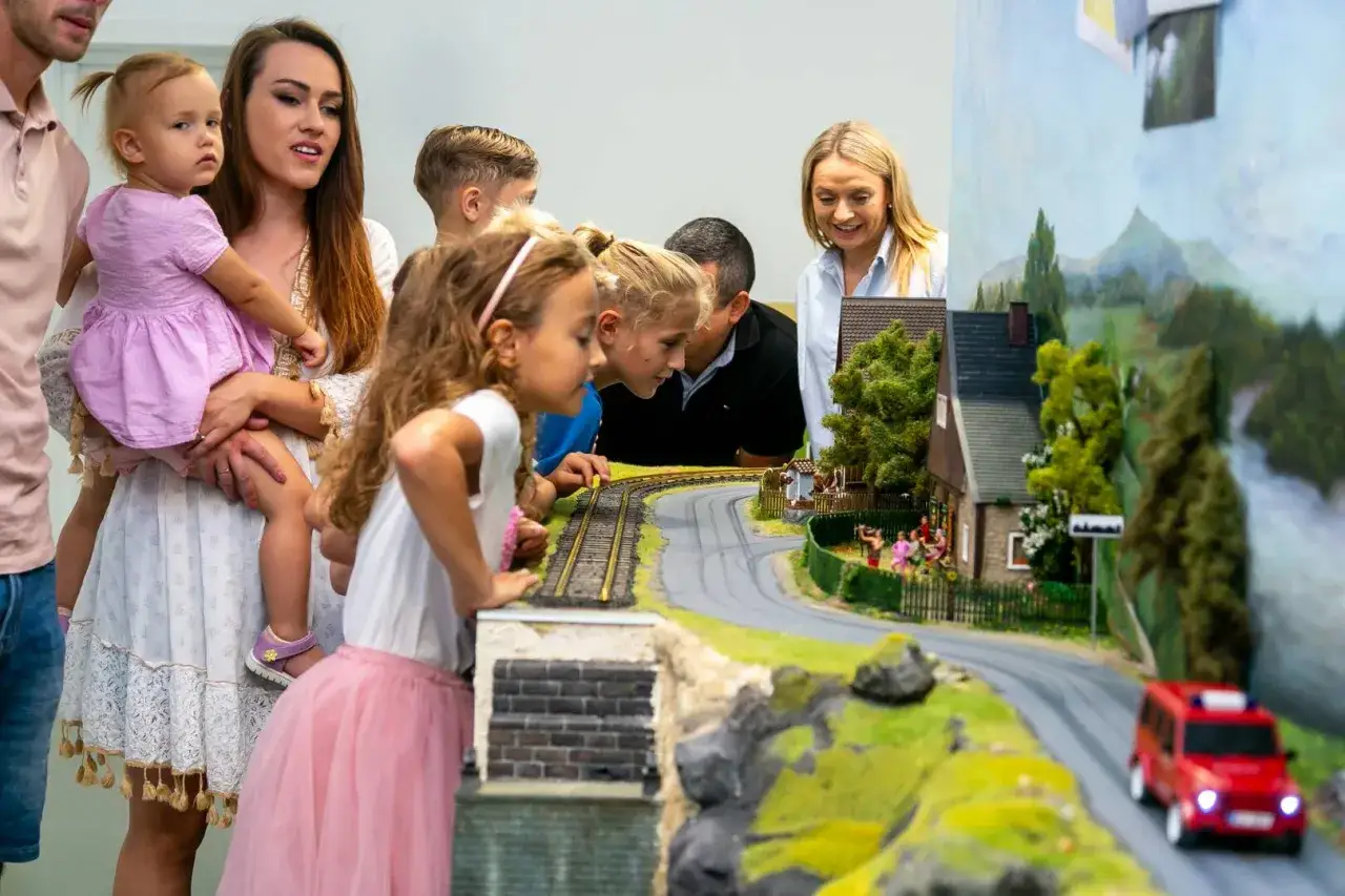 Rodzina podziwia miniaturową wioskę i kolejki, świetne atrakcje dla dzieci w Jeleniej G&oacute;rze.