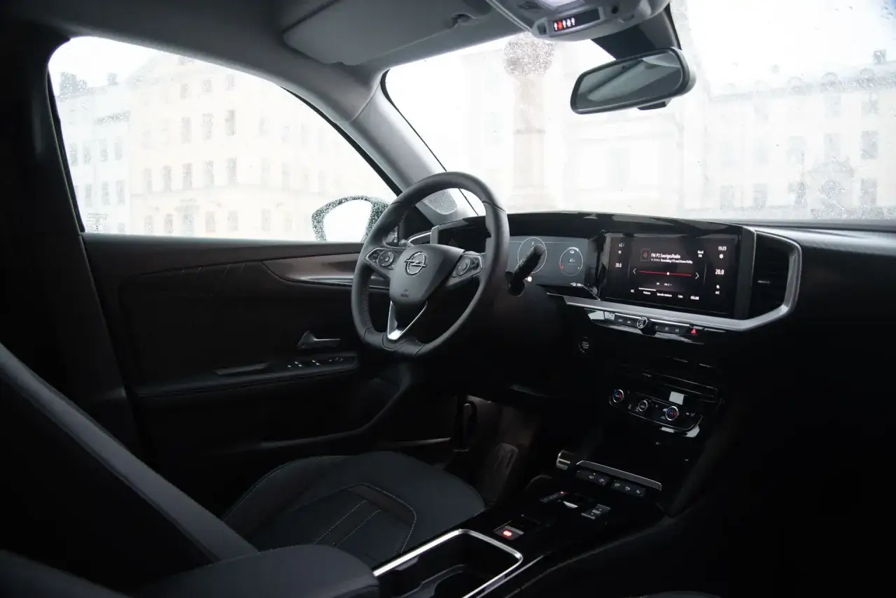 Interi&ouml;r i en Opel Mokka. Regn p&aring; vindrutan skapar en k&auml;nsla av ett problem med sikten, men bilens moderna instrumentpanel lyser upp.