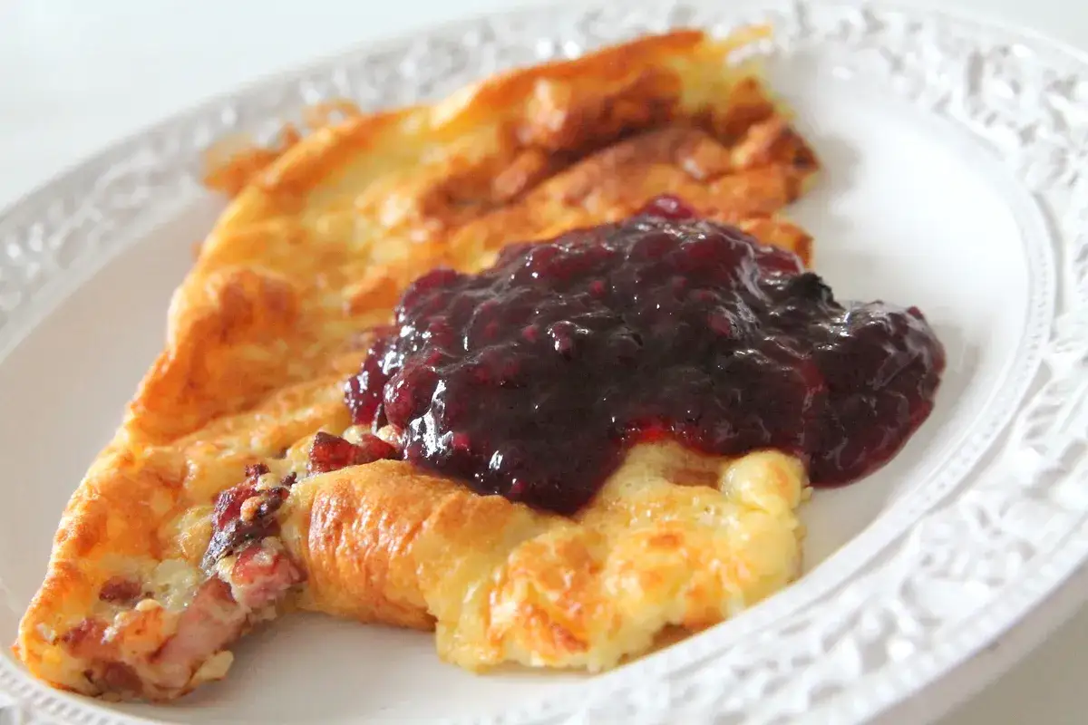En gyllene ugnspannkaka med en klick sylt. Perfekt f&ouml;r ett snabbt ugnspannkaka recept.