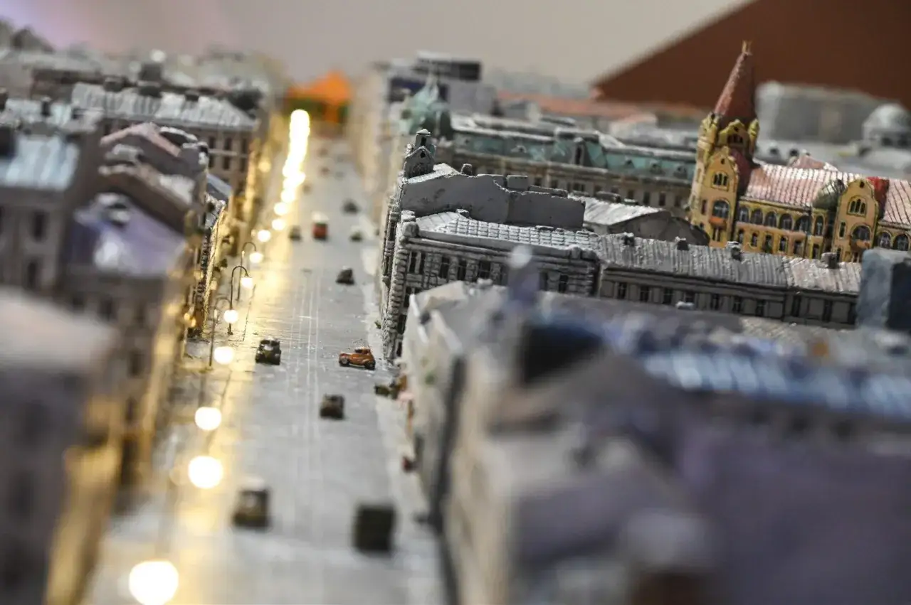 Miniaturowa ulica z samochodzikami i latarniami, jak w **parku miniatur Warszawa**.