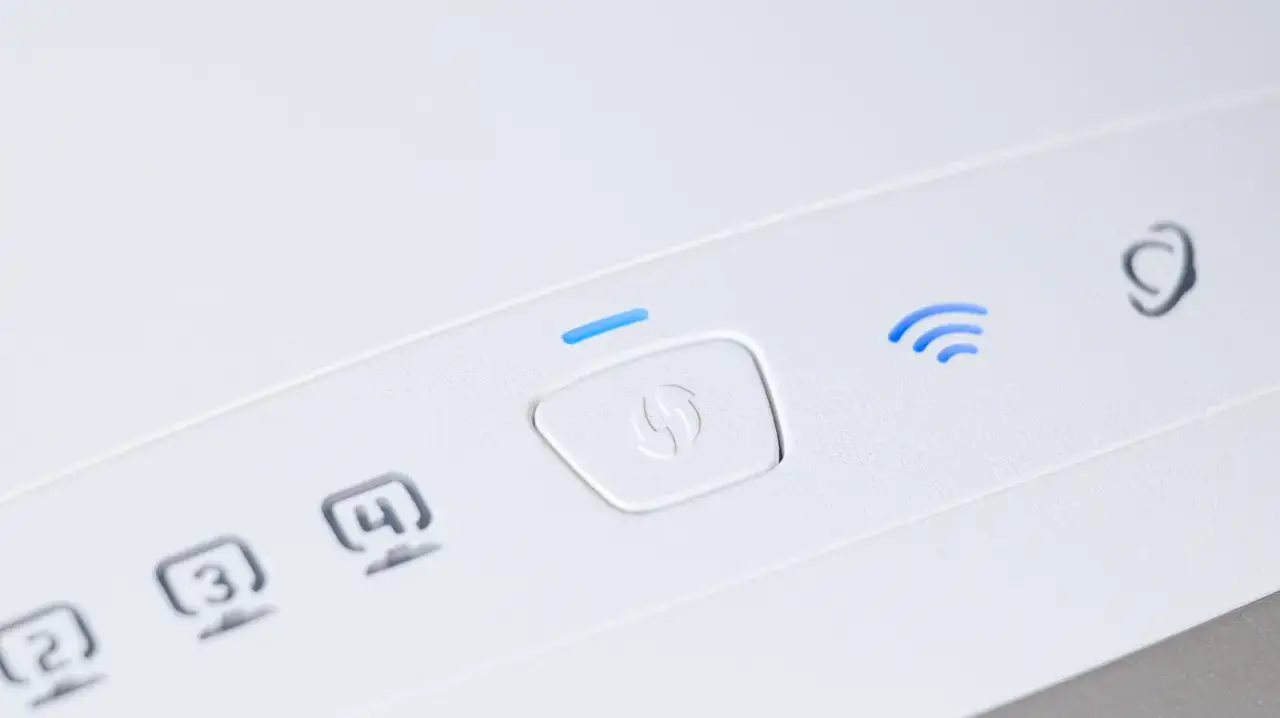 Biały router z podświetlonym na niebiesko przyciskiem WPS i ikoną Wi-Fi.