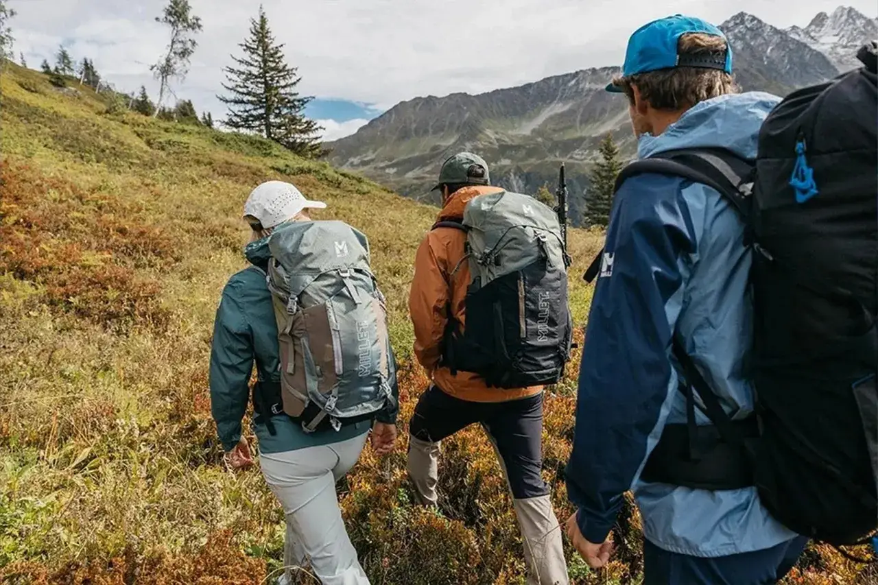 Trzy osoby w plecakach idące po górskim szlaku. To właśnie jest trekking – przygoda na łonie natury.