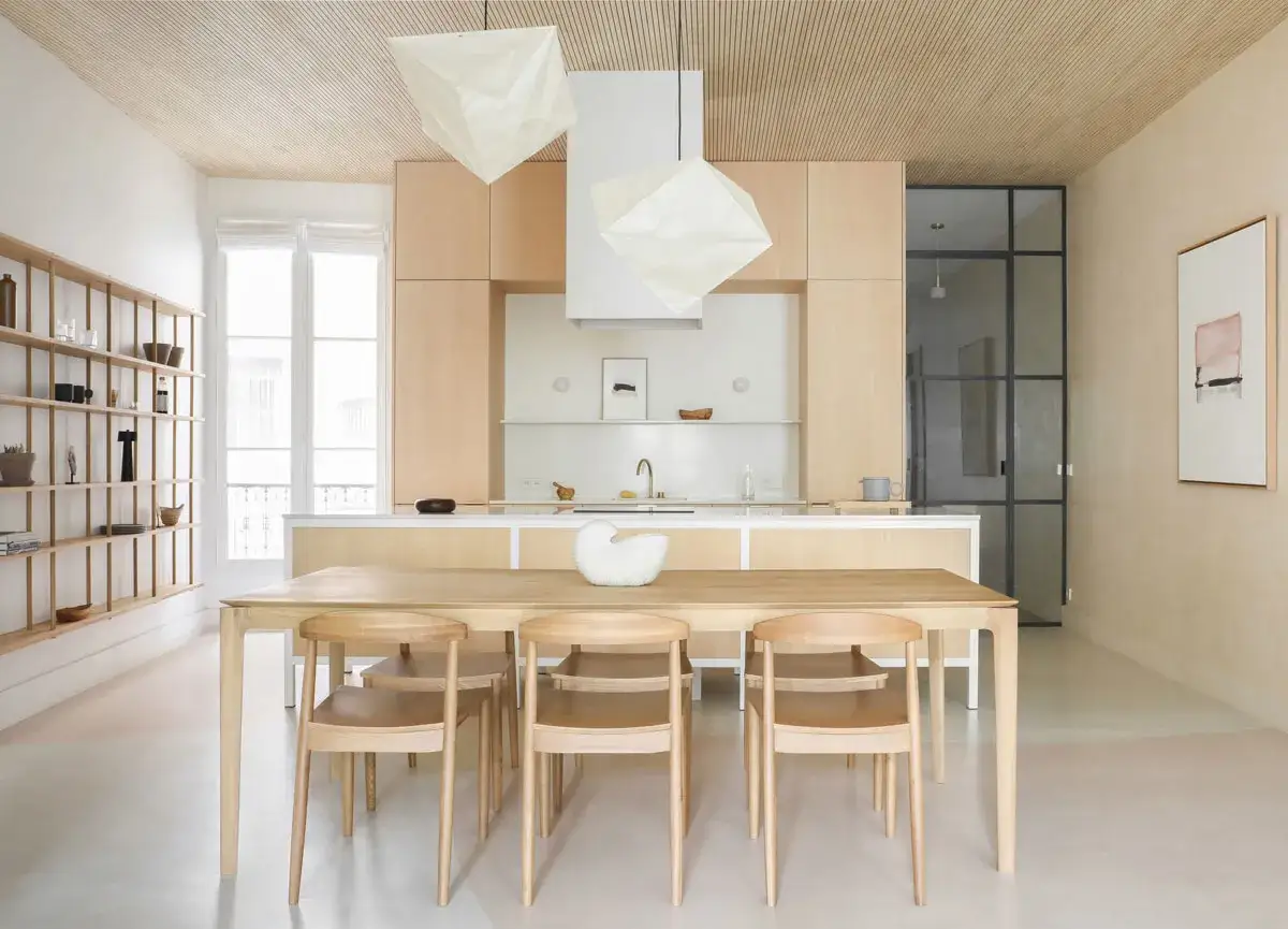 Cuisine lumineuse avec îlot central, table en bois et chaises épurées. Une **déco épurée chic** qui invite à la convivialité.
