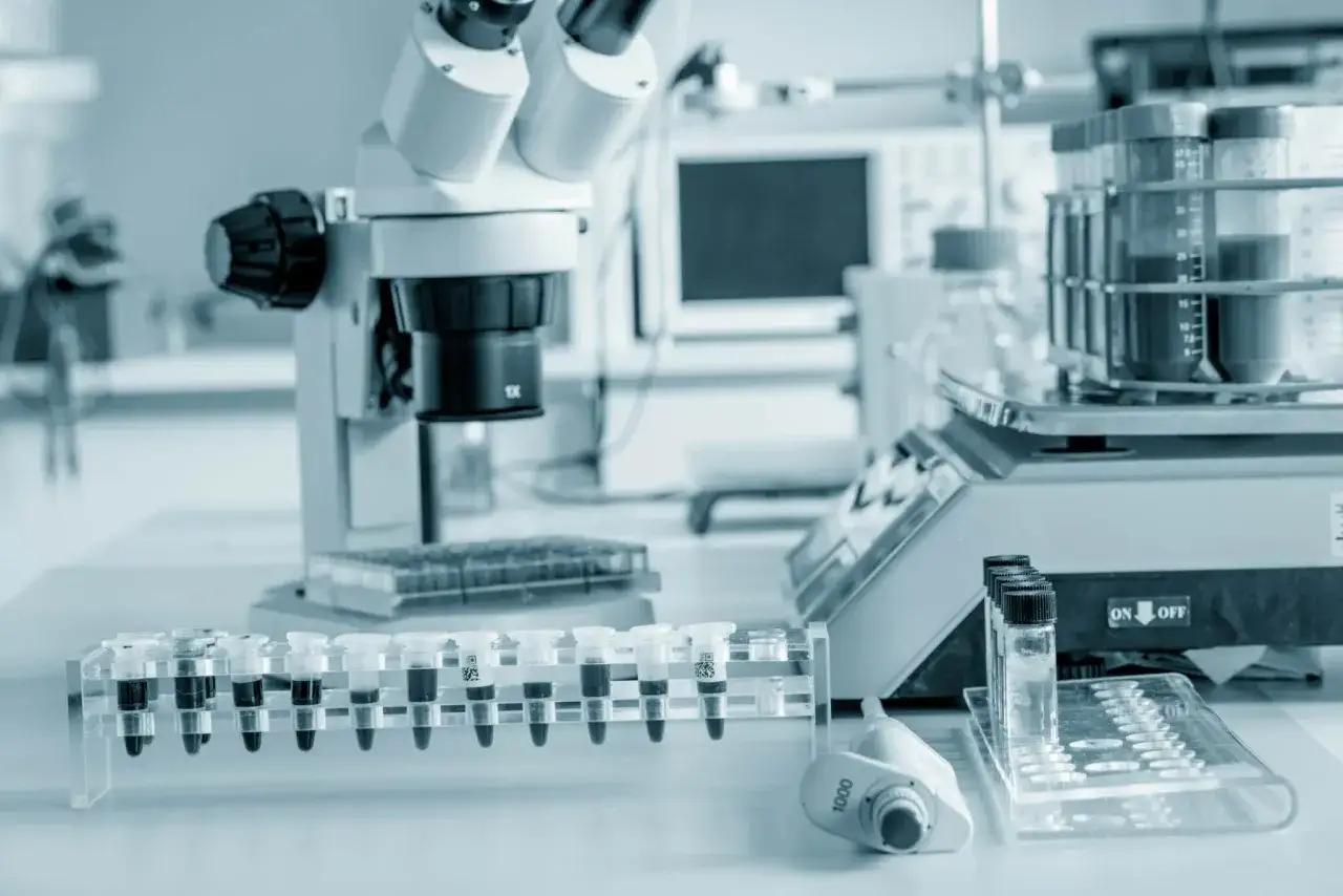 Microscopio y tubos de ensayo en laboratorio, listos para análisis de pcr en medicina.