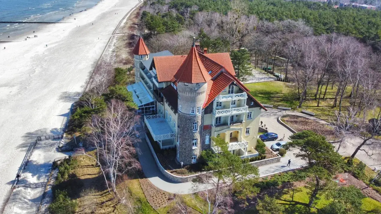 Łeba: pokoje z balkonem blisko morza. Malowniczy hotel z wieżyczkami i tarasami, tuż przy piaszczystej plaży i sosnowym lesie.