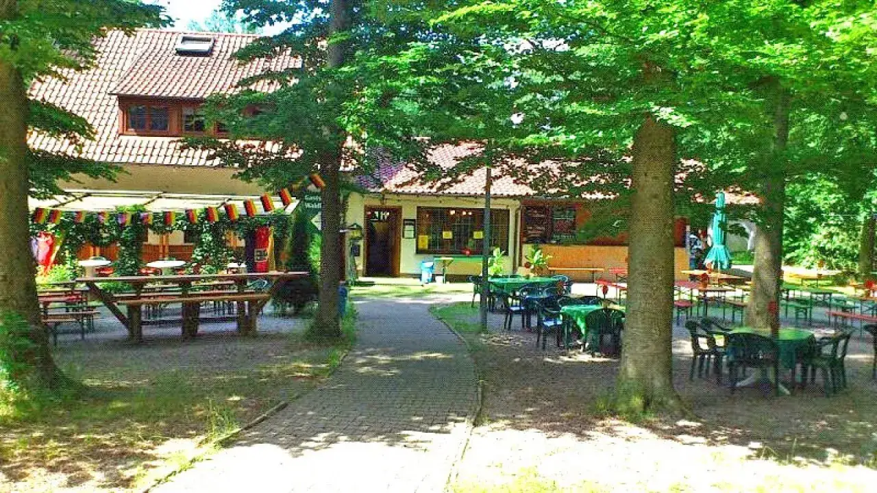 Einladende Biergartenatmosph&auml;re im Waldheim Backnang mit vielen Sitzgelegenheiten unter B&auml;umen und deutscher Beflaggung.