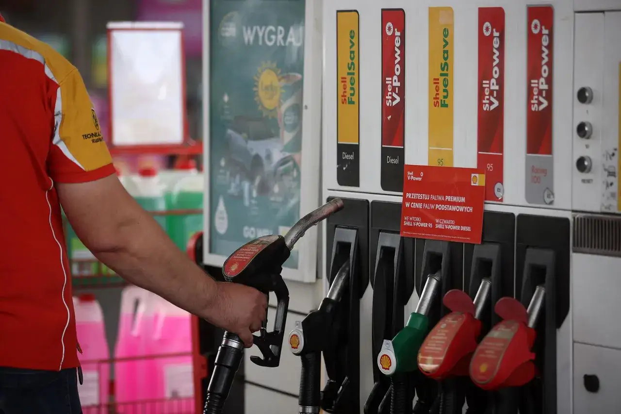 Pracownik stacji Shell z dystrybutorem paliwa. Czy to podpowie, ile zarabia się na stacji benzynowej?