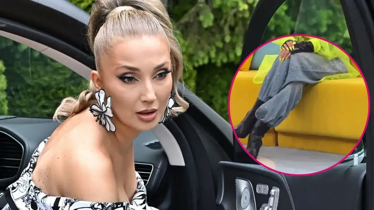 Cleo w samochodzie, w stylizacji z dużymi kolczykami. W kółku widać jej nogi w szarych spodniach i czarnych kozakach.