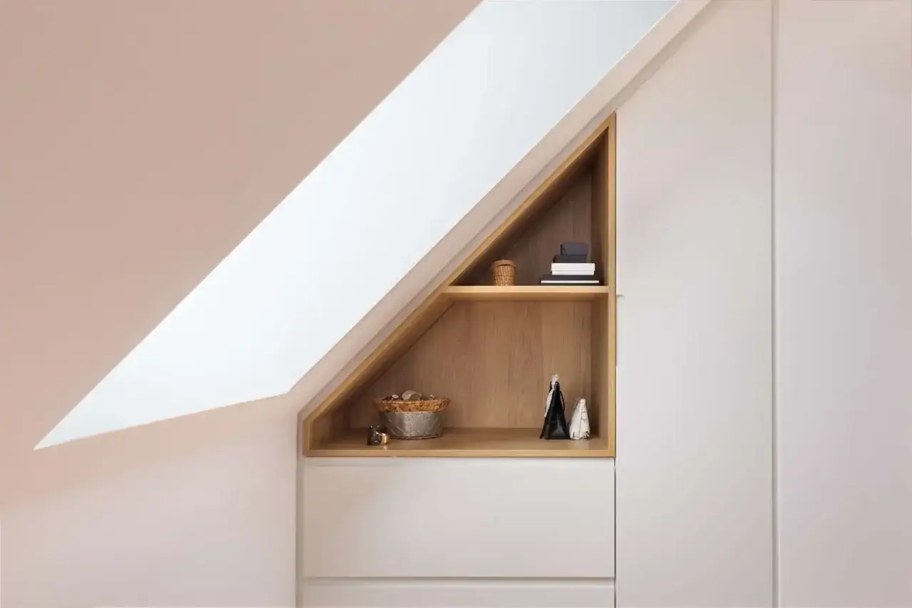 Id&eacute;es pour comment am&eacute;nager un grenier : &eacute;tag&egrave;res en bois dans un espace mansard&eacute;, avec des paniers, des livres et des objets d&eacute;coratifs.
