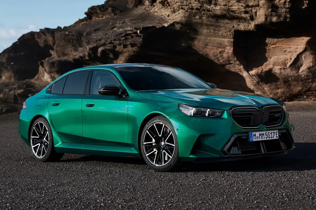 Zielony BMW G90 M na tle skalistego krajobrazu.