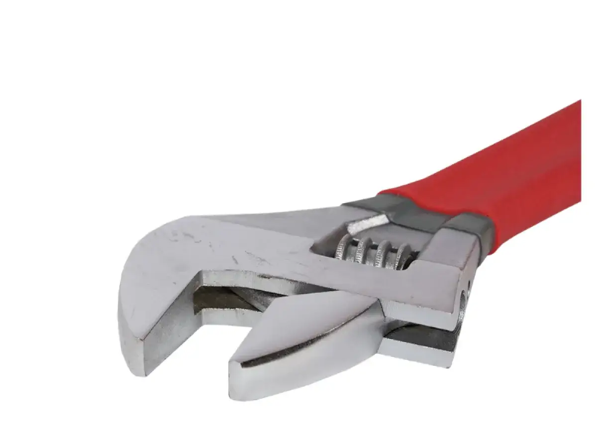Llave inglesa ajustable con mango rojo. Sirve para apretar o aflojar tuercas y tornillos de diferentes tamaños.