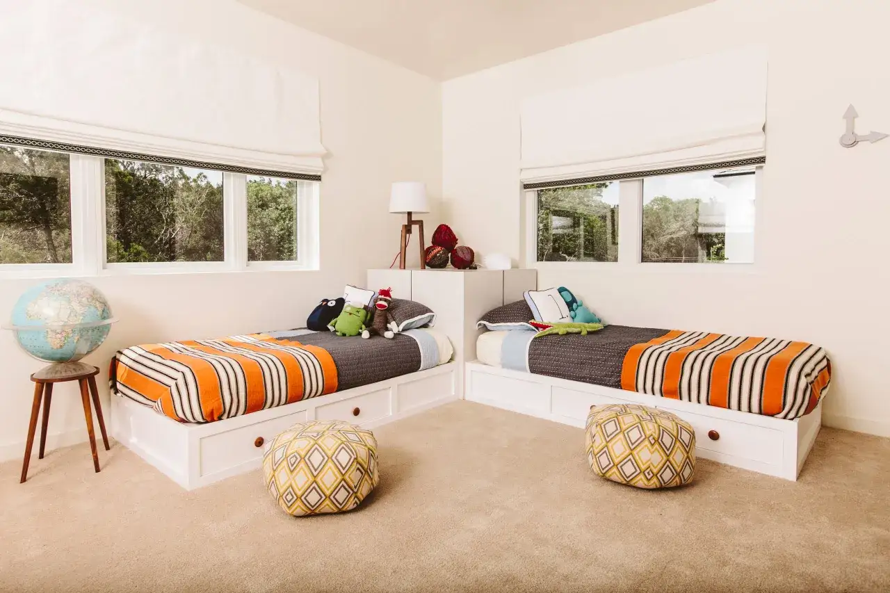 Ideas para poner dos camas en una habitaci&oacute;n peque&ntilde;a: camas gemelas con almacenamiento integrado, separadas por un rinc&oacute;n, con peluches y globos.