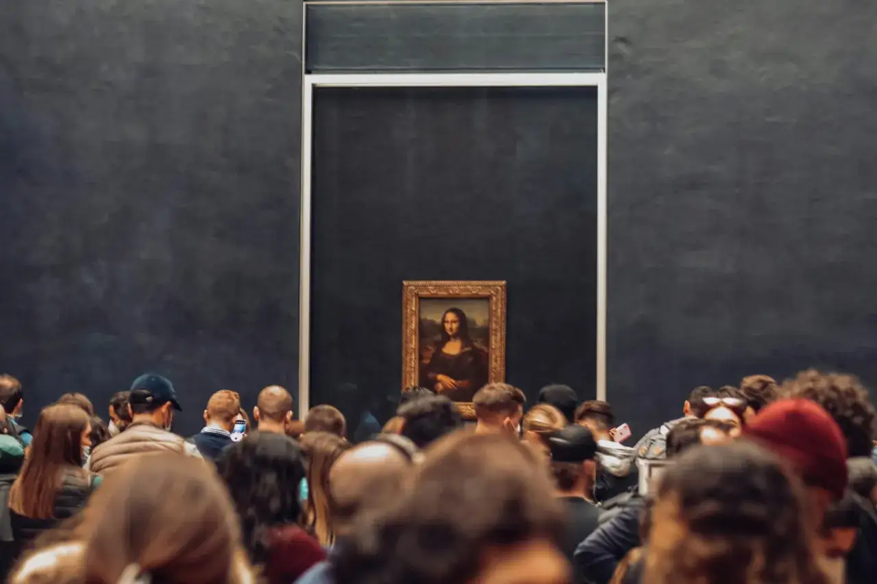 Tłum ludzi w muzeum podziwia obraz Mona Lisa.