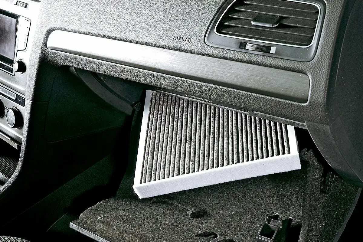 Ein staubiger Innenraumfilter im Handschuhfach des Autos. Dies kann zu **Feuchtigkeit im Auto** und schlechter Luftqualit&auml;t f&uuml;hren.