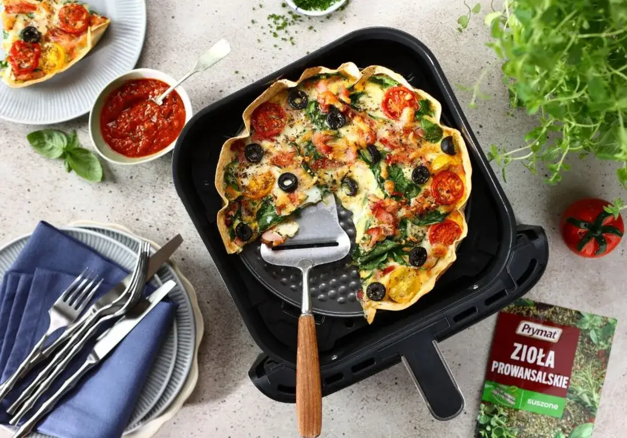 Pyszna tortilla z airfryer, z pomidorkami, oliwkami i szpinakiem, gotowa do podania.