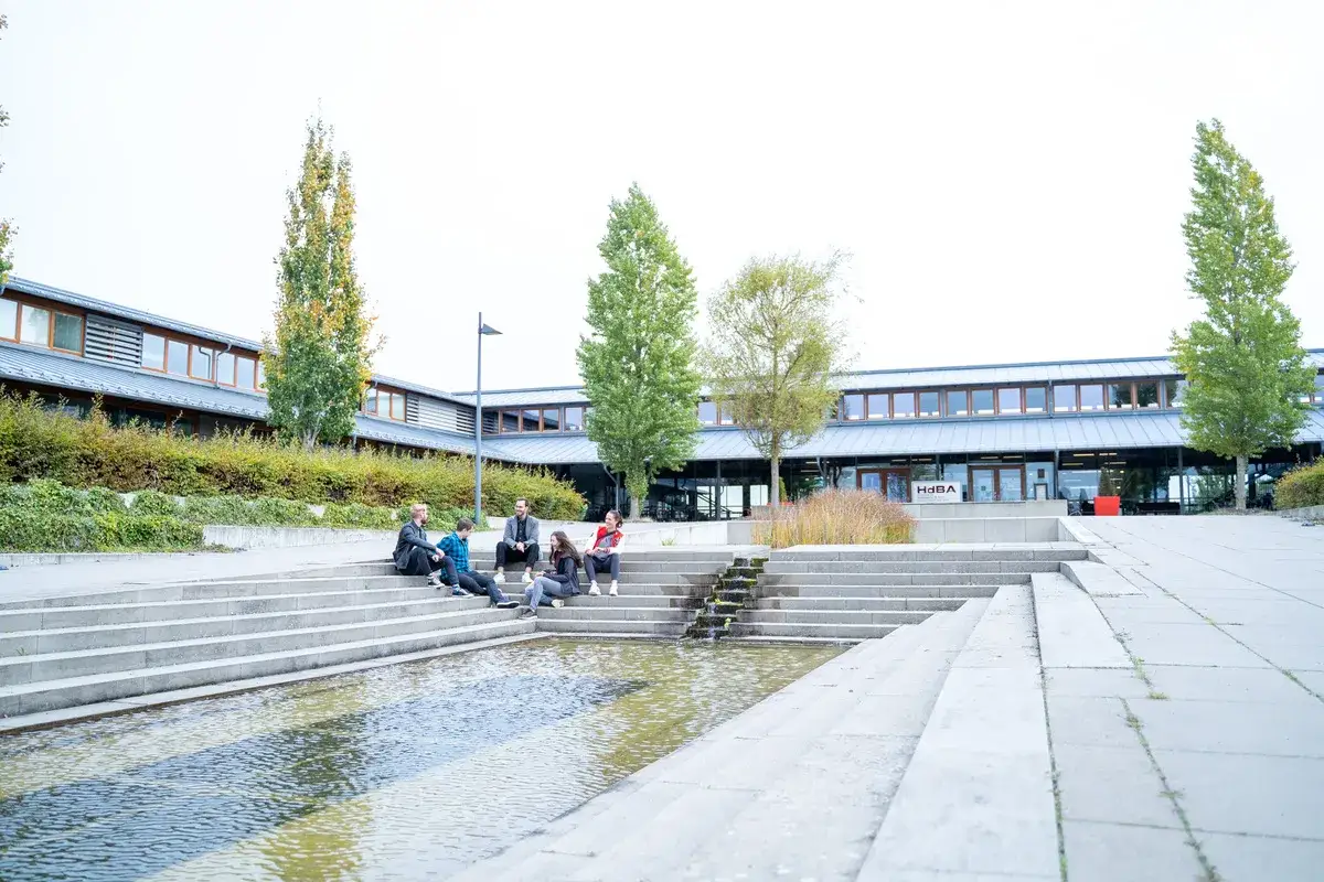 Studierende entspannen sich auf den Treppen vor der Uni Schwerin.