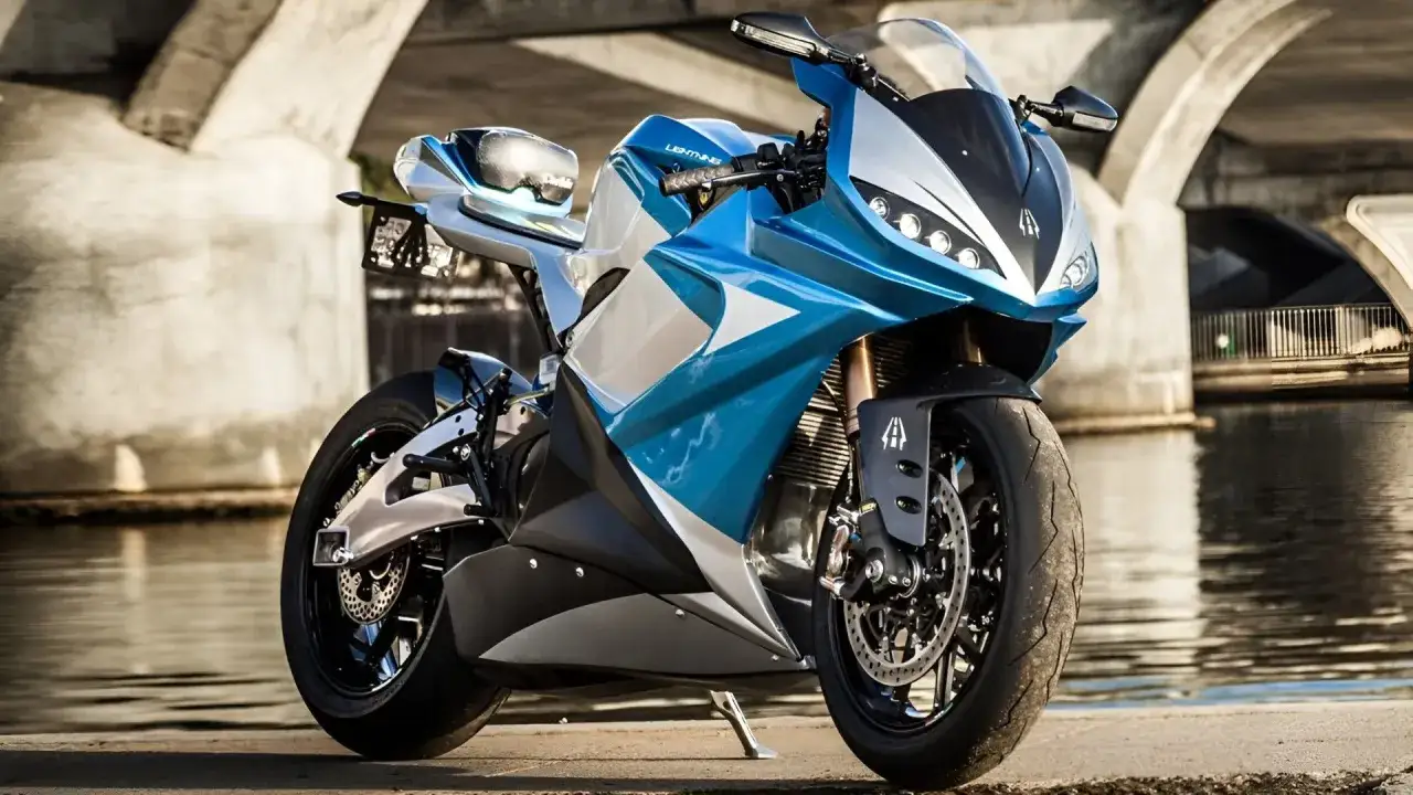 Una moto el&eacute;ctrica azul y plateada, la m&aacute;s potente, descansa junto a un r&iacute;o bajo un puente.