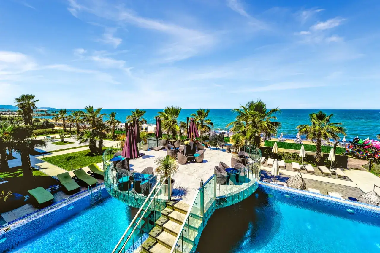 Albania - wczasy samolotem all inclusive. Basen, palmy i widok na morze. Idealne miejsce na relaks i wypoczynek.
