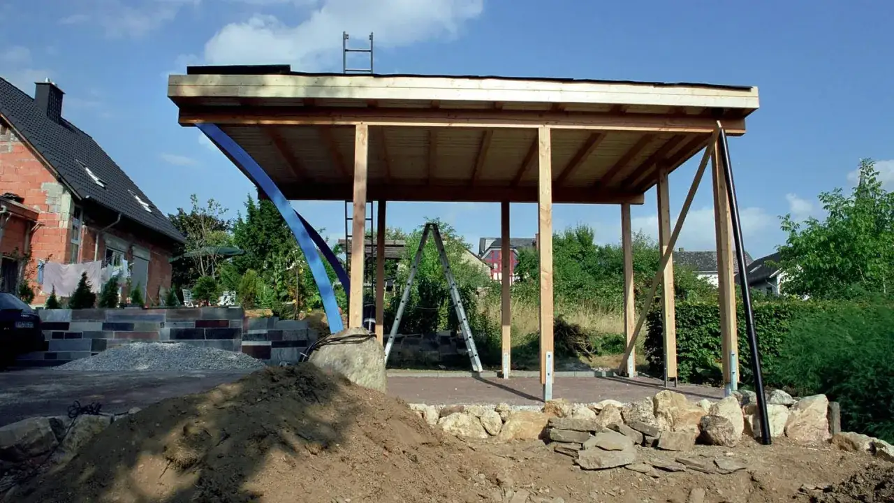 Bau eines Carports: ab wann braucht man eine baugenehmigung? Das Holzger&uuml;st steht, die Dachpappe ist verlegt. Leitern und Baumaterial deuten auf den Fortschritt hin.