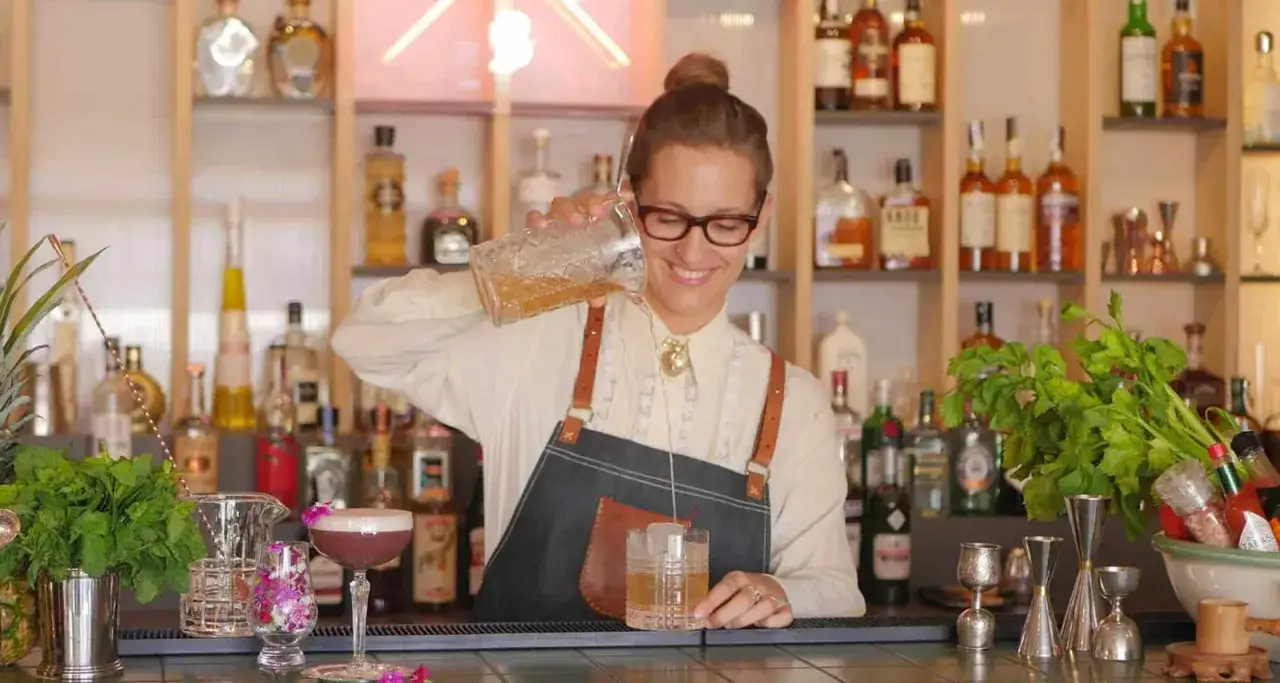 Uśmiechnięta barmanka nalewa drinka. Zastanawiasz się, ile zarabia barman w Kanadzie?