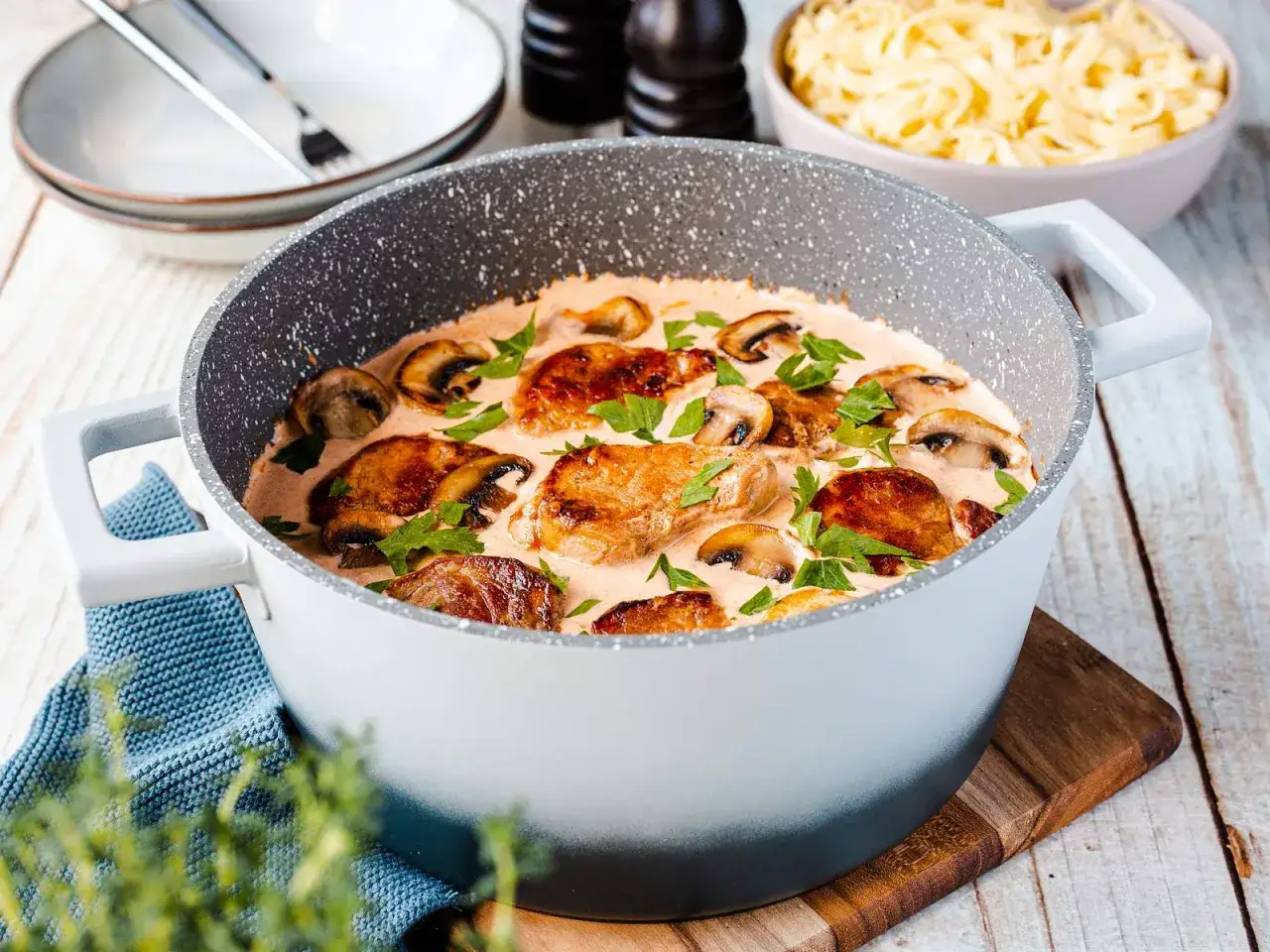 Saftiges schweinefilet mit champignons in cremiger Sauce, garniert mit Petersilie, bereit zum Servieren mit Pasta.