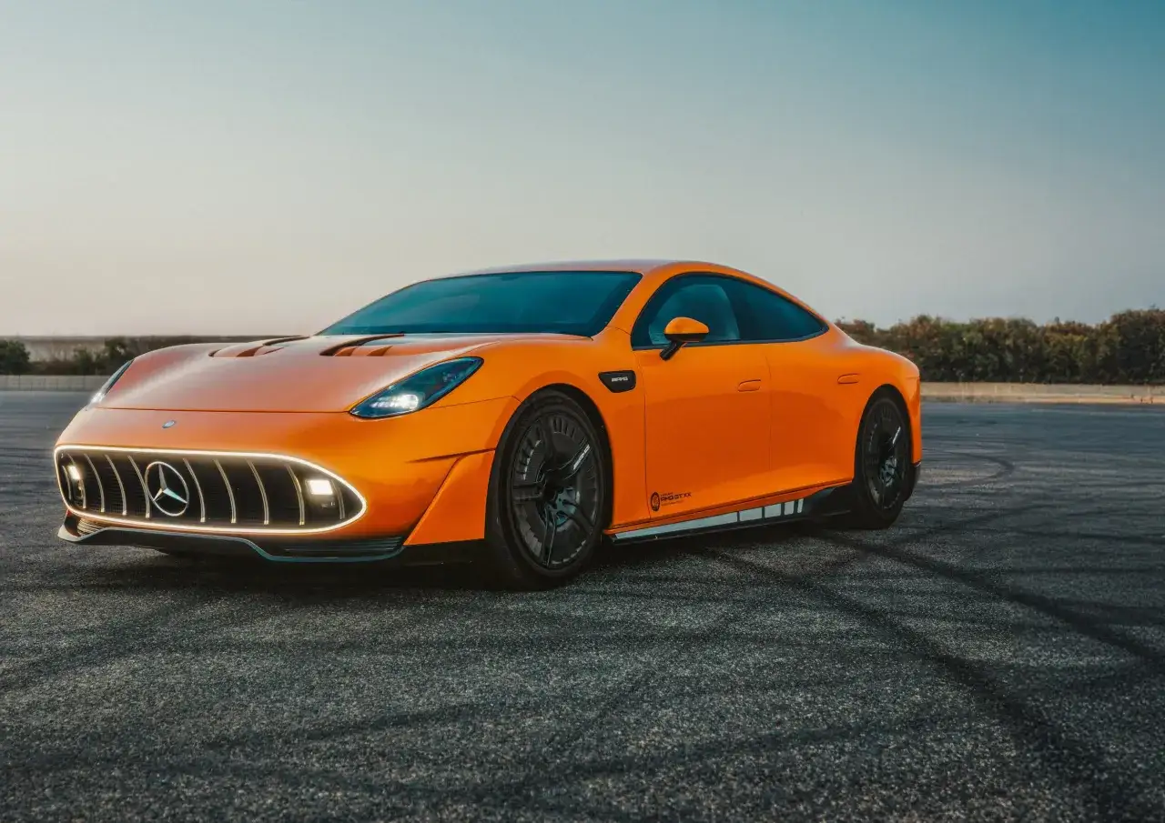 Pomarańczowy Mercedes-AMG GT XX, być może najlepszy samochód na świecie, z charakterystycznym grillem i sportowymi felgami na tle nieba.