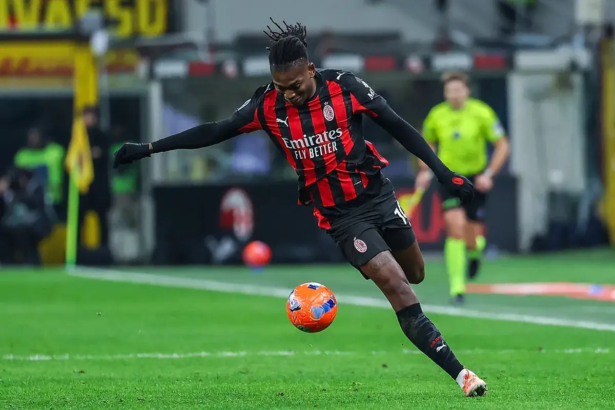 Piłkarz AC Milan w akcji podczas meczu z Lazio. Rafael Leão drybluje z piłką, gotowy do strzału.