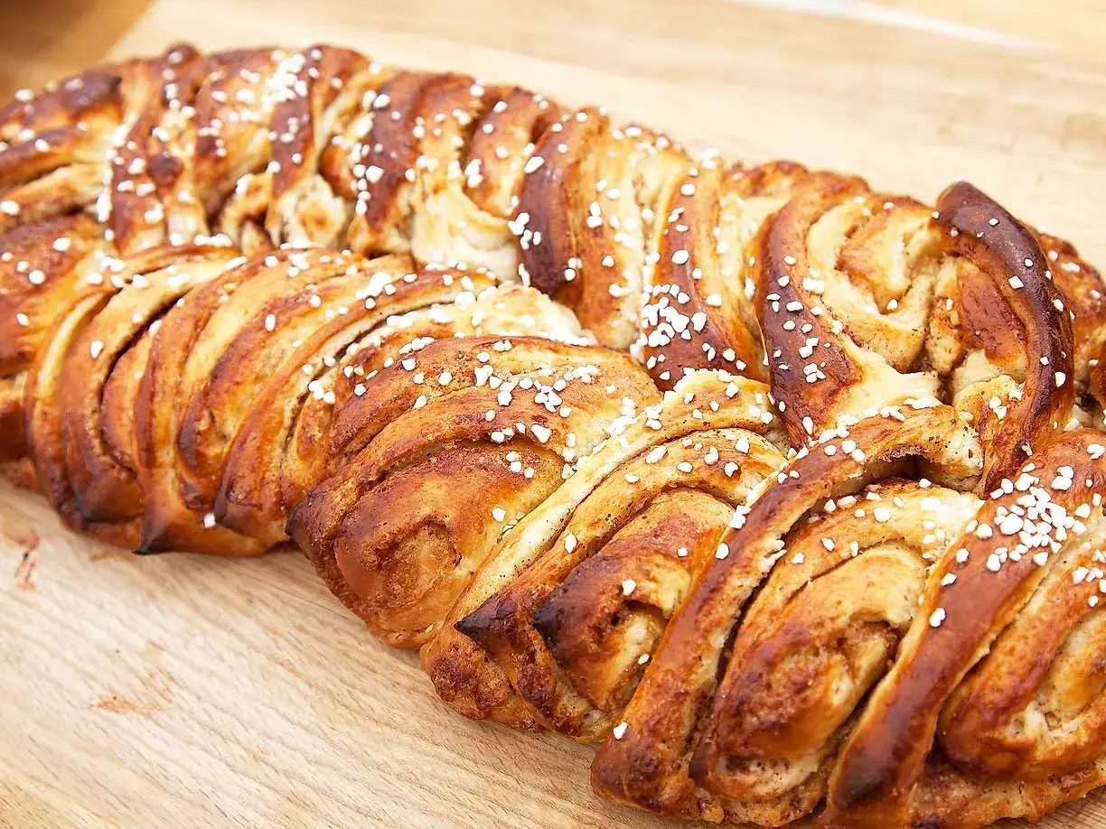 Tv&aring; gyllene vetel&auml;ngder, perfekt gr&auml;ddade och str&ouml;sslade med p&auml;rlsocker, ligger p&aring; en tr&auml;sk&auml;rbr&auml;da.