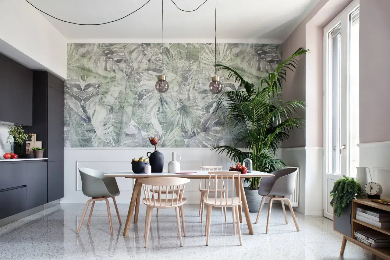 La parete dietro il tavolo da pranzo &egrave; decorata con una carta da parati a tema tropicale, che crea un'atmosfera esotica.