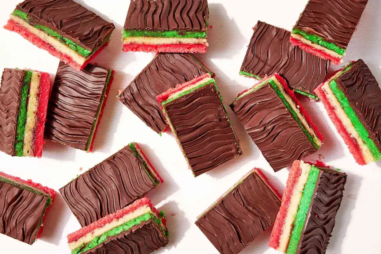 Flera rektangul&auml;ra bitar av en italiensk dessert med lager av r&ouml;tt, vitt och gr&ouml;nt kex, t&auml;ckta med m&ouml;rk choklad med v&aring;gm&ouml;nster.