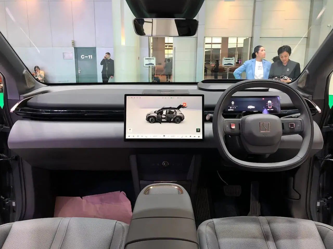 Interior del Zeekr X con pantalla táctil central mostrando un coche y volante digital.