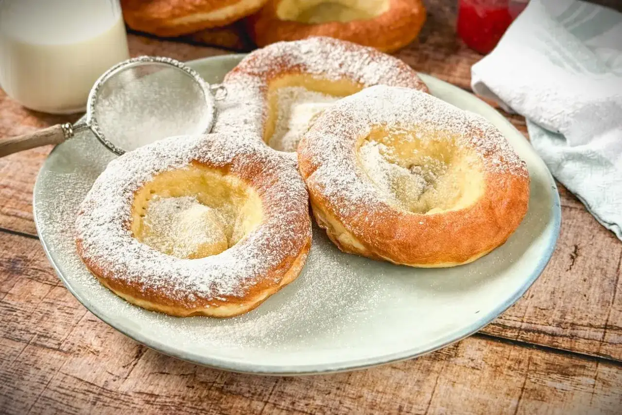 Ausgezogene Bayern, frisch gebacken und mit Puderzucker best&auml;ubt, warten auf ein Glas Milch.