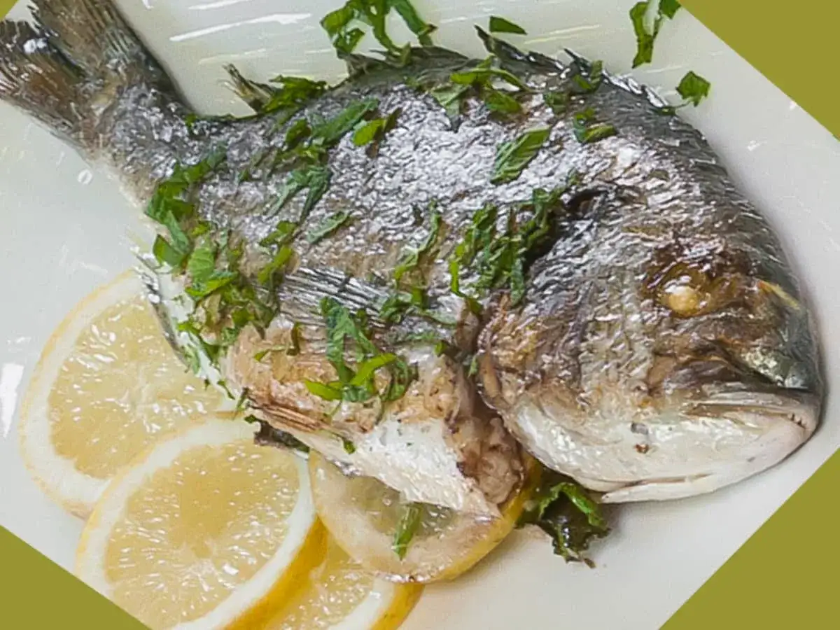 Dorade grillée garnie d'herbes fraîches, servie avec des rondelles de citron. Un délice simple et savoureux.