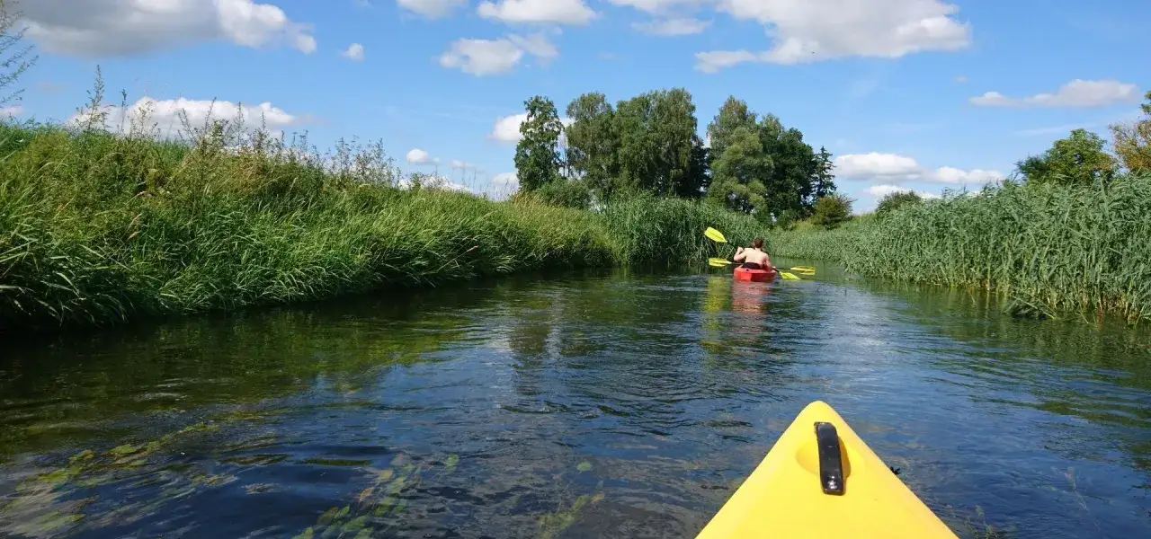 Idealne miejsce, gdzie na Mazury we dwoje. Płyniemy kajakiem po spokojnej rzece, otoczeni zielenią.