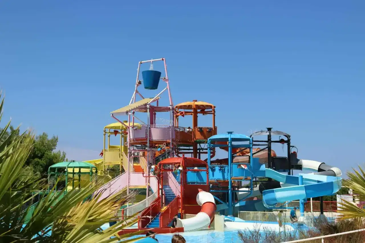 Kolorowy aquapark na Złotym Brzegu w Bułgarii, z mn&oacute;stwem zjeżdżalni i atrakcji wodnych, zaprasza do zabawy pod błękitnym niebem.