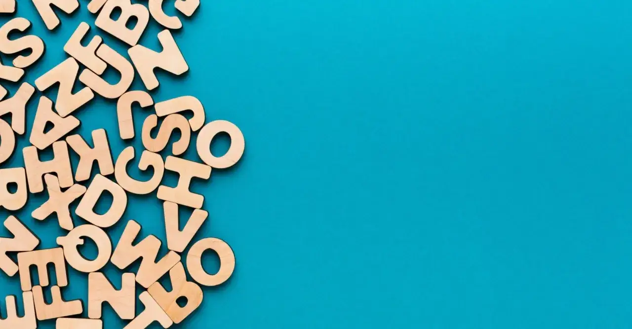 Lettere di legno sparse su sfondo blu, come un chiasmo visivo che evoca il significato delle parole.