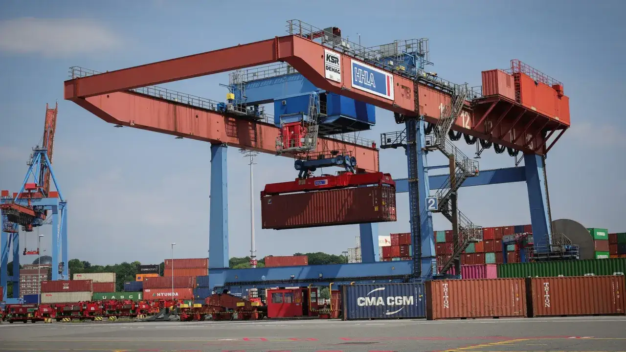 Gro&szlig;er Hafenkran hebt Container. Dies ist ein Beispiel f&uuml;r die **terminal handling charges** im globalen Handel.