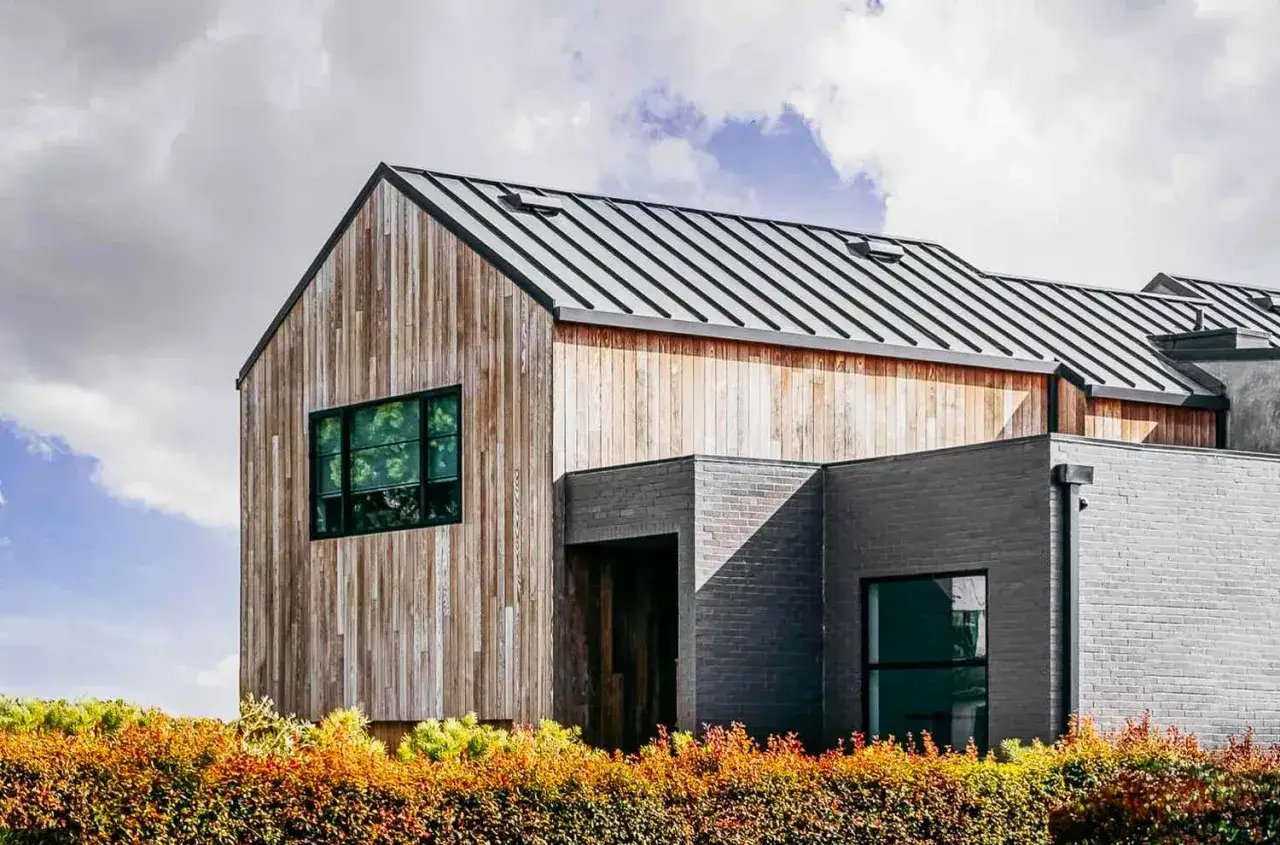 Casas estilo nórdico moderno con fachadas de madera y ladrillo, techos metálicos y grandes ventanales.