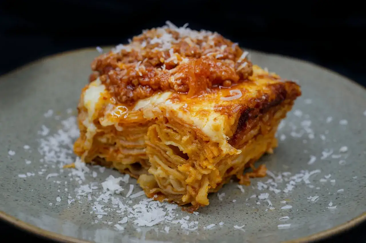 Ein Stück Lasagne Bolognese, das nach einem original italienischen lasagne rezept zubereitet wurde, mit viel Käse und einer herzhaften Fleischsauce.