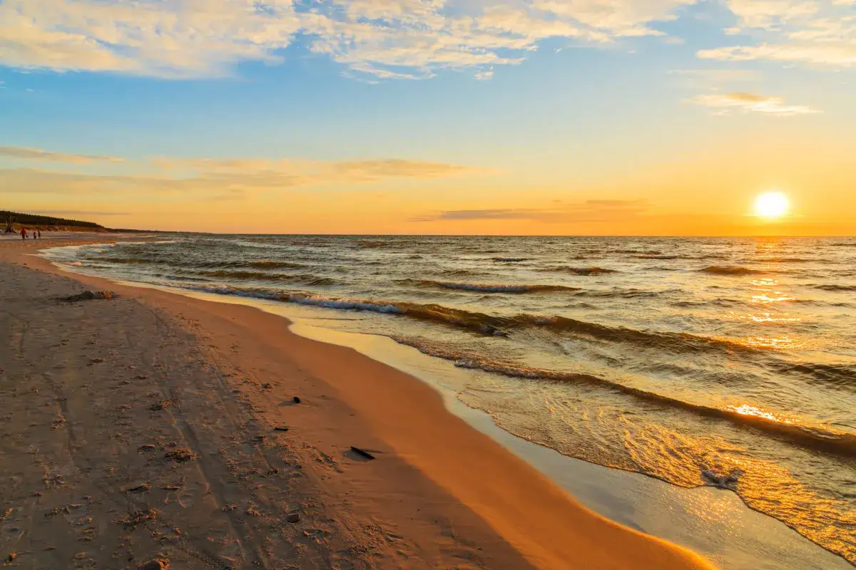 Piękny zachód słońca międzyzdroje. Złote światło odbija się od fal, a piaszczysta plaża zaprasza do spaceru.