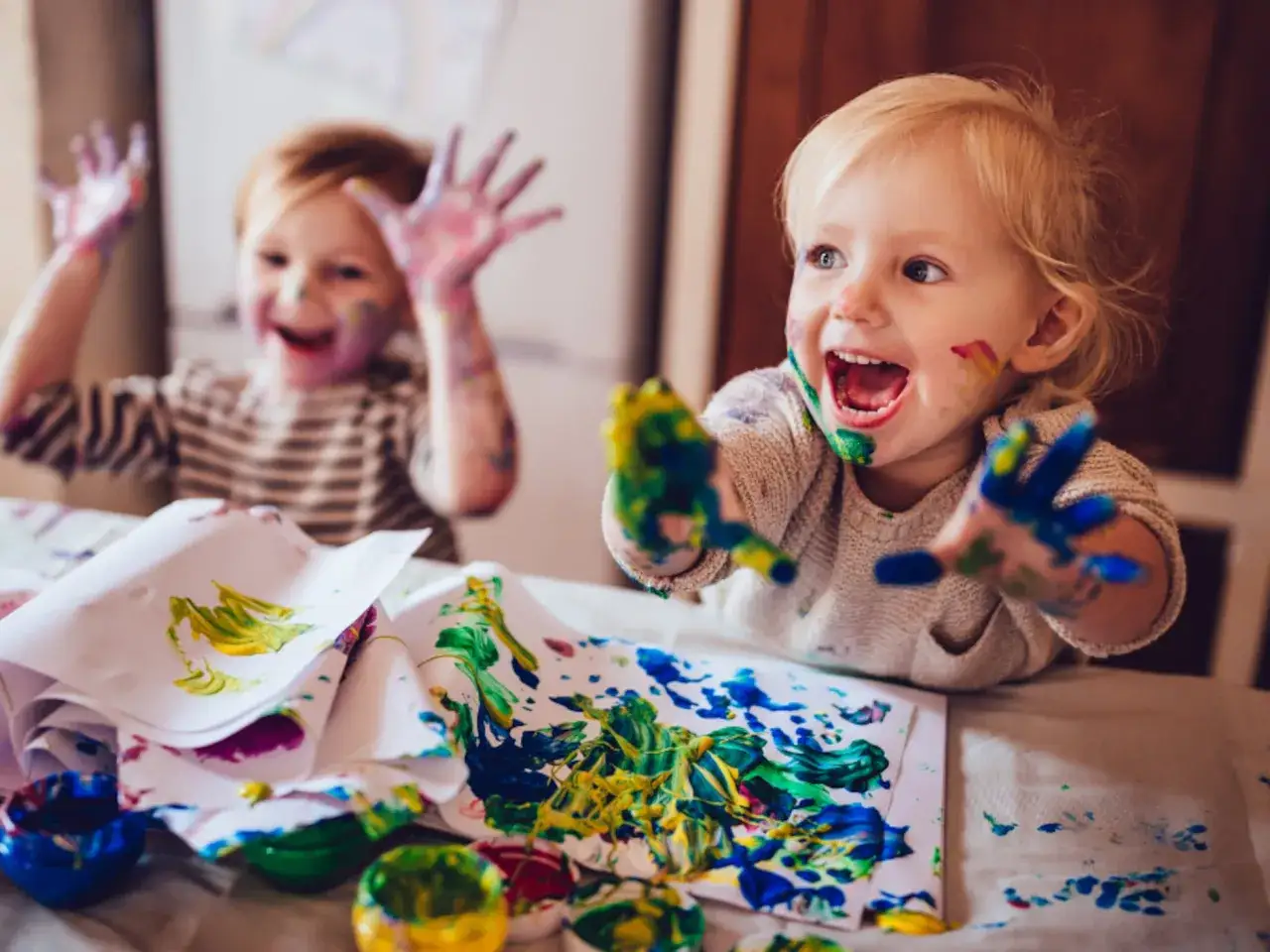 Ni&ntilde;os peque&ntilde;os disfrutando de actividades para ni&ntilde;os de 2 a 3 a&ntilde;os, pintando con las manos y llen&aacute;ndose de colores.