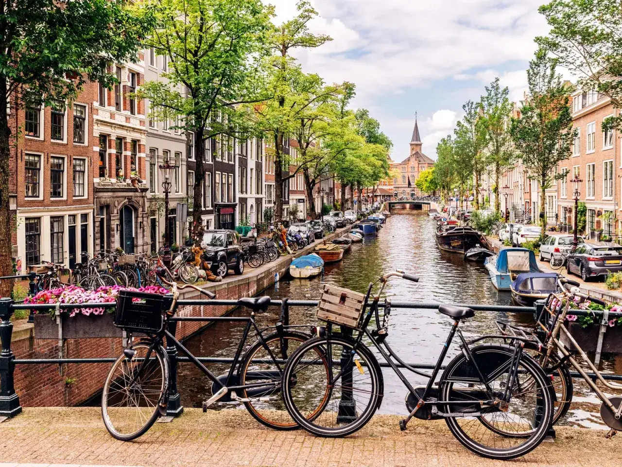 En klassisk Amsterdam-vy med kanaler, husbåtar och cyklar. Perfekt för din amsterdam reseguide.