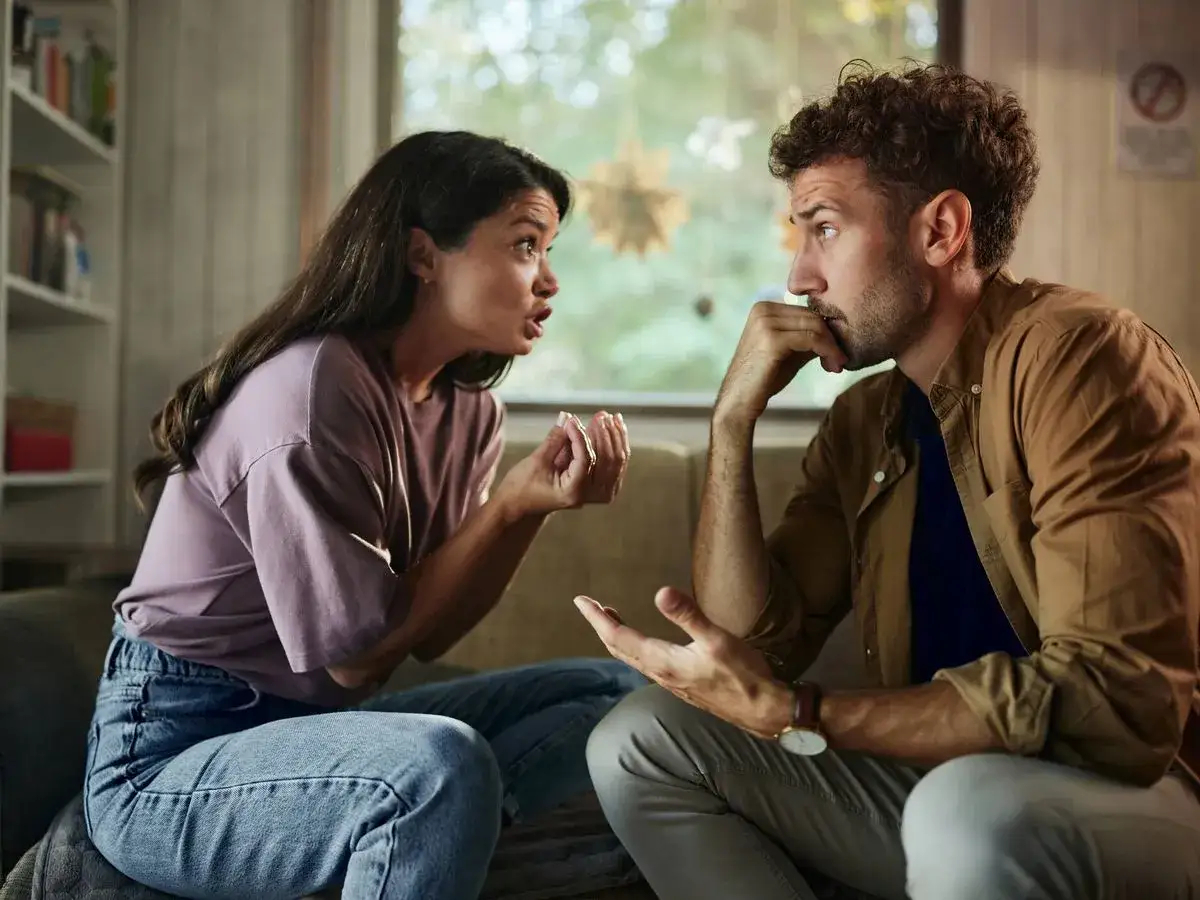 Pareja discutiendo, ella gesticula con las manos, &eacute;l escucha pensativo. Una escena de comunicaci&oacute;n abierta, buscando entenderse.