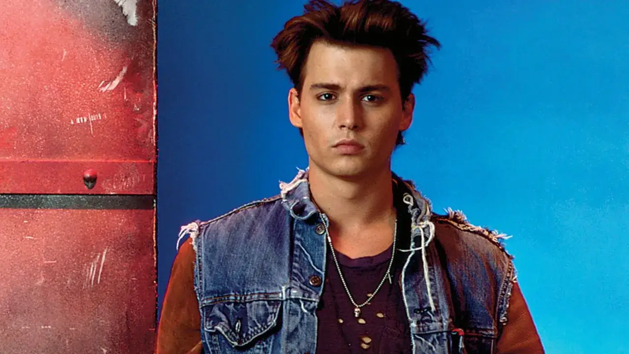 Johnny Depp ung i sliten jeansv&auml;st och trasig t-shirt, med en kedja runt halsen.