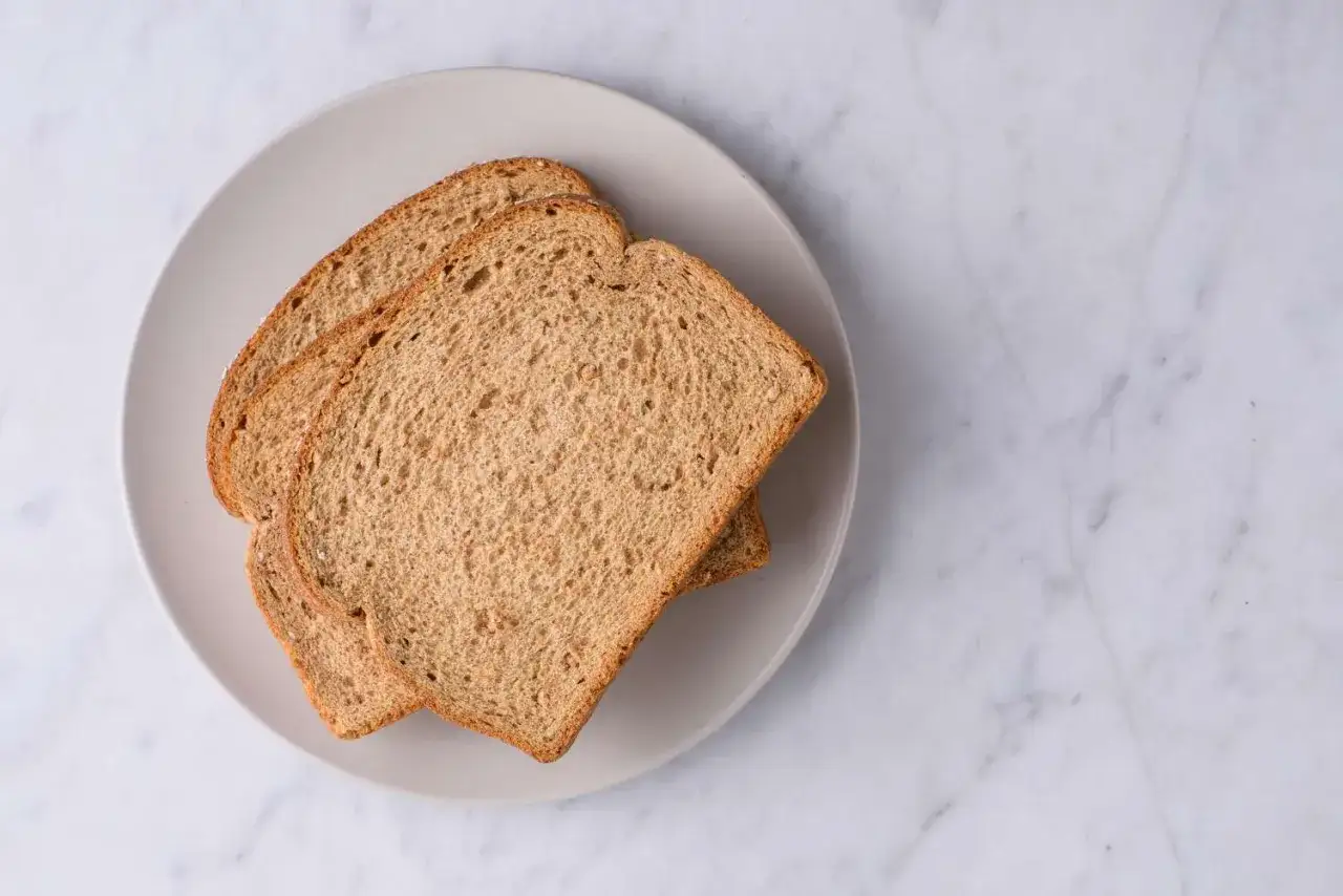 Drei Scheiben Vollkornbrot auf einem Teller. Kalorienbewusstes Fr&uuml;hst&uuml;ck: 2 Scheiben Schwarzbrot.